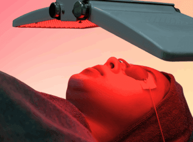 Woman with eye protection goggles laying under red light